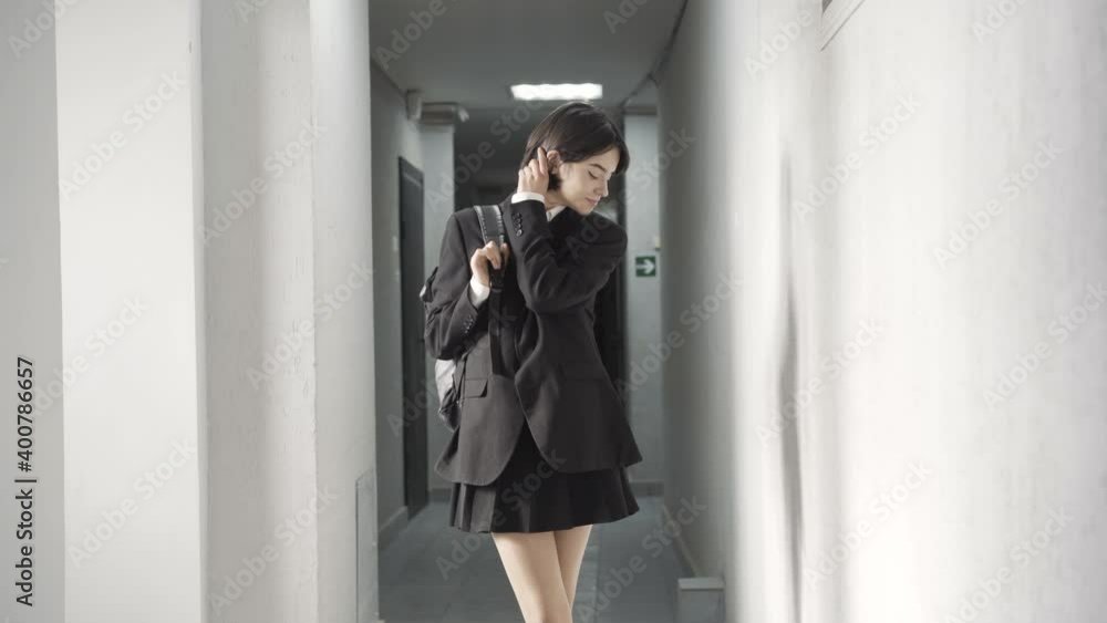 Portrait of pretty positive teenage girl posing in high school corridor. Smiling beautiful brunette Caucasian student looking at camera and smiling. Lifestyle and adolescence education. Portrait of pretty positive teenage girl posing in high school corridor. Smiling beautiful brunette Caucasian student looking at camera and smiling. Lifestyle and adolescence education.