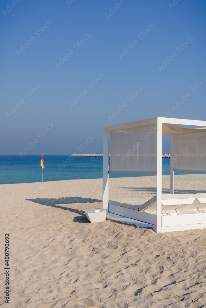 Fototapeta premium Relaxing empty beach with sun bed, sea landscape. Summer vacation travel holiday concept.