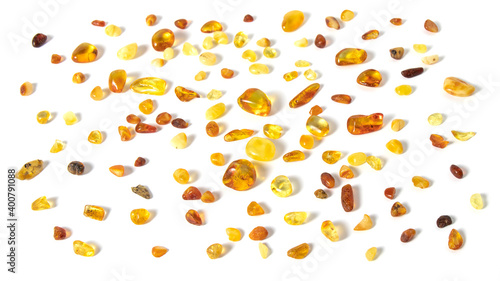 Fototapeta Naklejka Na Ścianę i Meble -  Sparkling pieces of natural Baltic amber on the white background. Ancient magical amber is protection powers love luck healing strength. Texture of amber.