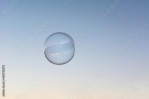 A soap bubble flying in the blue and clean sky