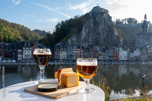 Drinking of dark and strong Belgian abbey beer with cheeses with nice view on Maas river and town Dinant, Belgium photo