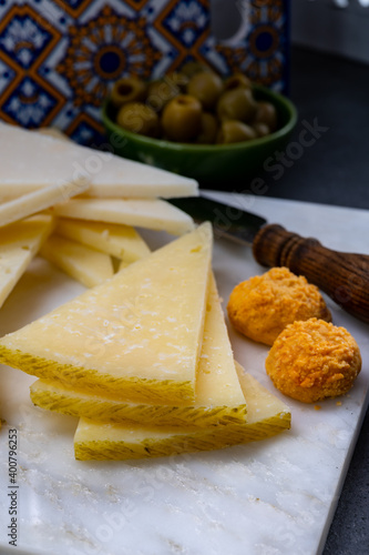 Spanish snacks tapas, variety of sliced goat, sheep, manchego cheeses, green olives