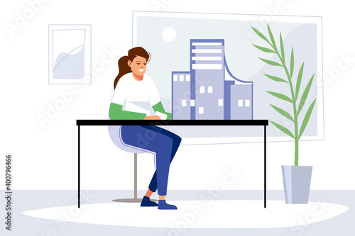 A young girl architect constructs a layout of a future multi-storey house at home office on a desktop. A modern flat room in blue tones. Indoor plant.  