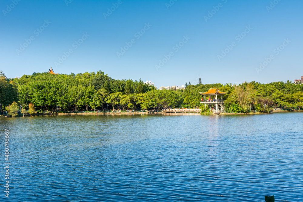 Obraz premium Lake, island, green forest and Chinese traditional pavilion against blue sky in longtan Park, Longgang, Shenzhen, China
