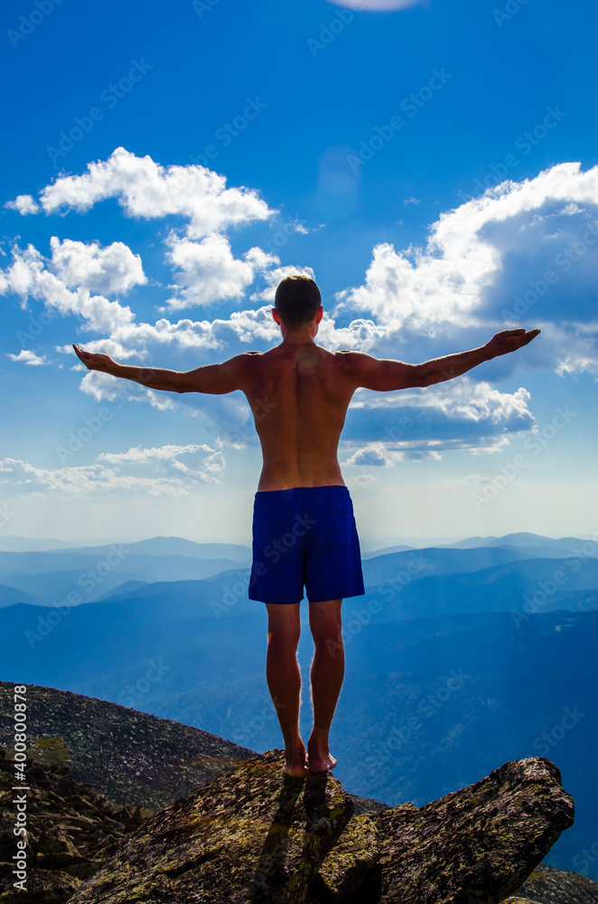 man stands on top of a mountain with open hand man stands on top of a mountain with open hand