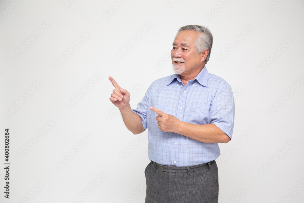 Senior Asian man smiling and pointing to empty copy space isolated on white background Senior Asian man smiling and pointing to empty copy space isolated on white background