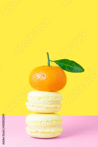 Two lemon French pasta with orange tangerine on a pink and yellow background. Vertical photo. Valentine's day gift