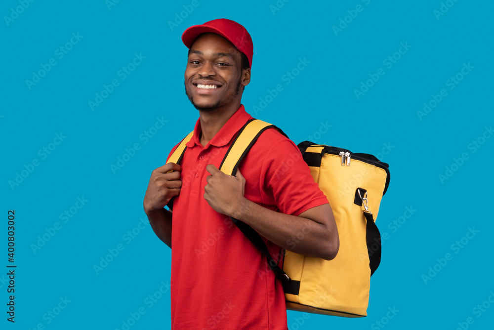 Black delivery man posing with thermo bag looking at camera Black delivery man posing with thermo bag looking at camera
