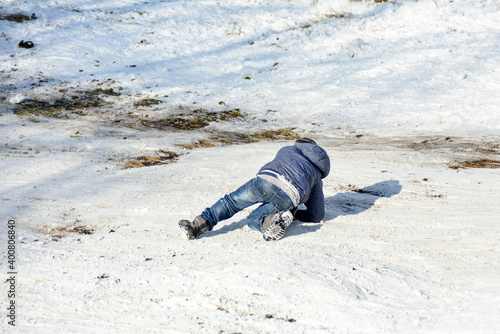 The boy fell down the slide and tried to get up. photo