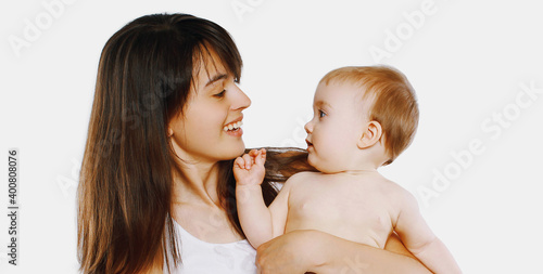 Portrait of cheerful smiling mother and baby playing together over a white background