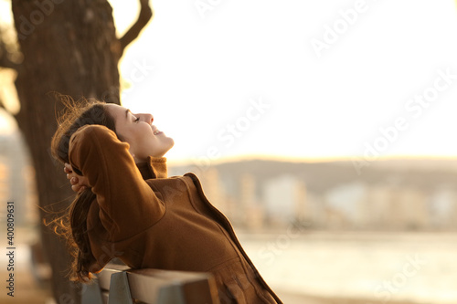 Fotografie Woman resting sitting on a bench on the beach in winter
