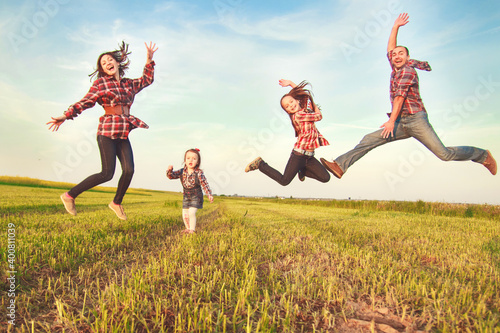 happy family jumping in the field