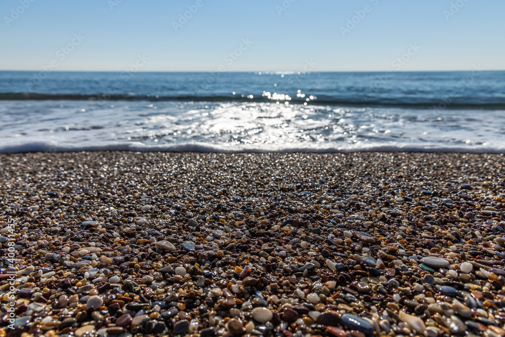 Sparkling waves on the beach hits the pebble beach in Antalya Turkey, Holiday and Travel concept, sunny and blue sky, nobody, no people, space for text, selective focus. Sparkling waves on the beach hits the pebble beach in Antalya Turkey, Holiday and Travel concept, sunny and blue sky, nobody, no people, space for text, selective focus.