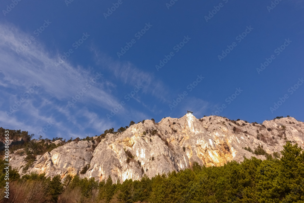 high rocky mountain wall with skywalk and blue sky