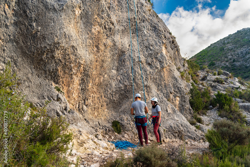 Healthy lifestyle climber couple preparing to start climbing next to a stone wall in nature