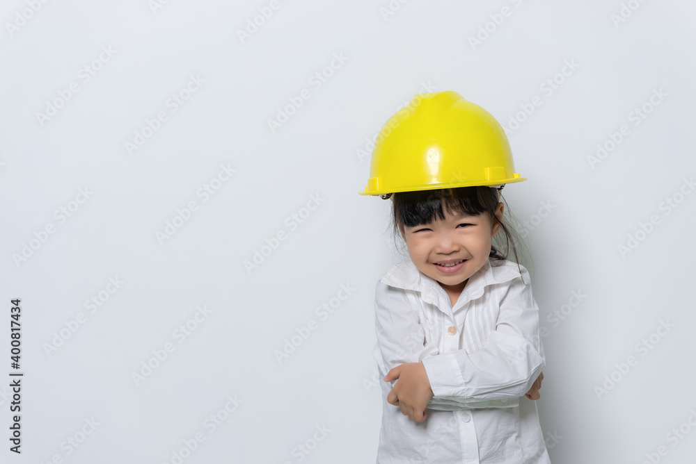 Portrait of cute asian little girl in engineer uniform and helmet on white background