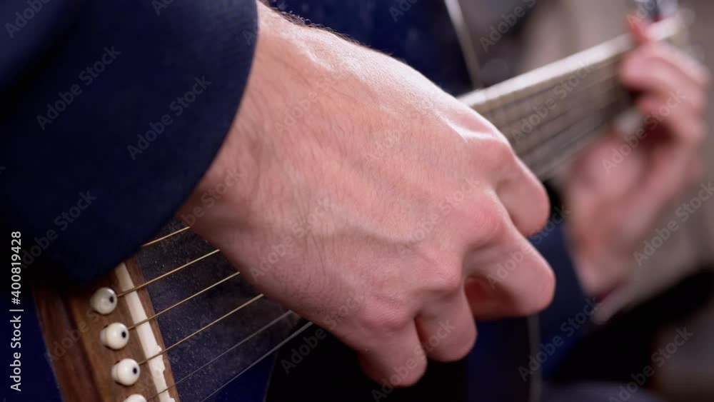 Guitarist Male Fingers Play Strings of an Acoustic Guitar at Home. Close-Up Guitarist Male Fingers Play Strings of an Acoustic Guitar at Home. Close-Up