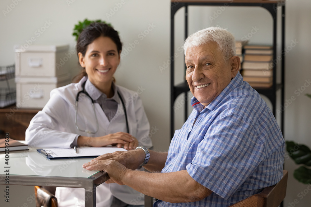 Obraz premium Portrait of happy mature 80s male patient feel satisfied after good quality service in hospital. Smiling senior man client at consultation with female doctor in clinic. Elderly healthcare concept.
