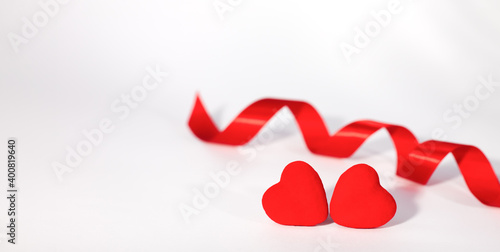 Two red hearts and red ribbon on white background. Concept for Valentin's day. Banner. Place for text.