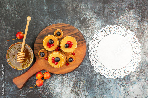 Breakfast time with fruit pancakes on cutting board on gray background photo