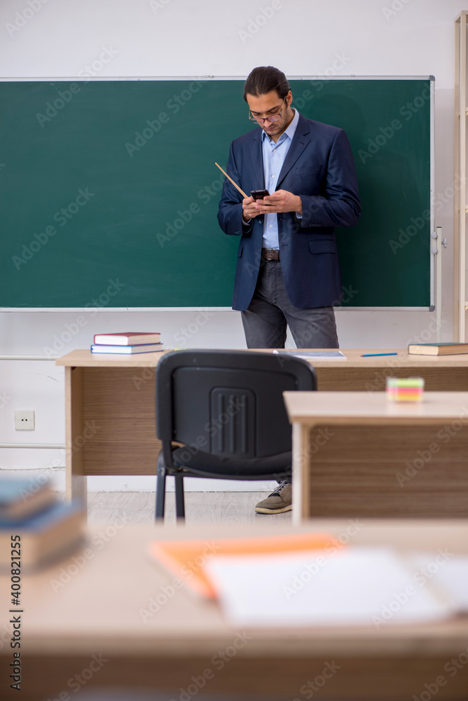 Young male teacher in front of green board Young male teacher in front of green board