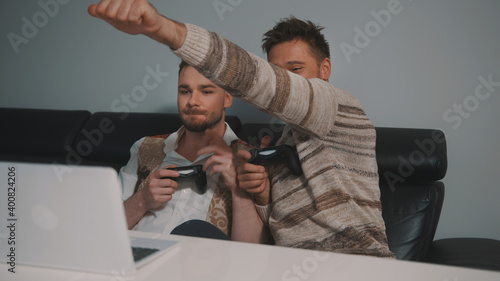 Young gay couple playing video games using joystic controller. Lifestyle of same sex partners. High quality photo photo