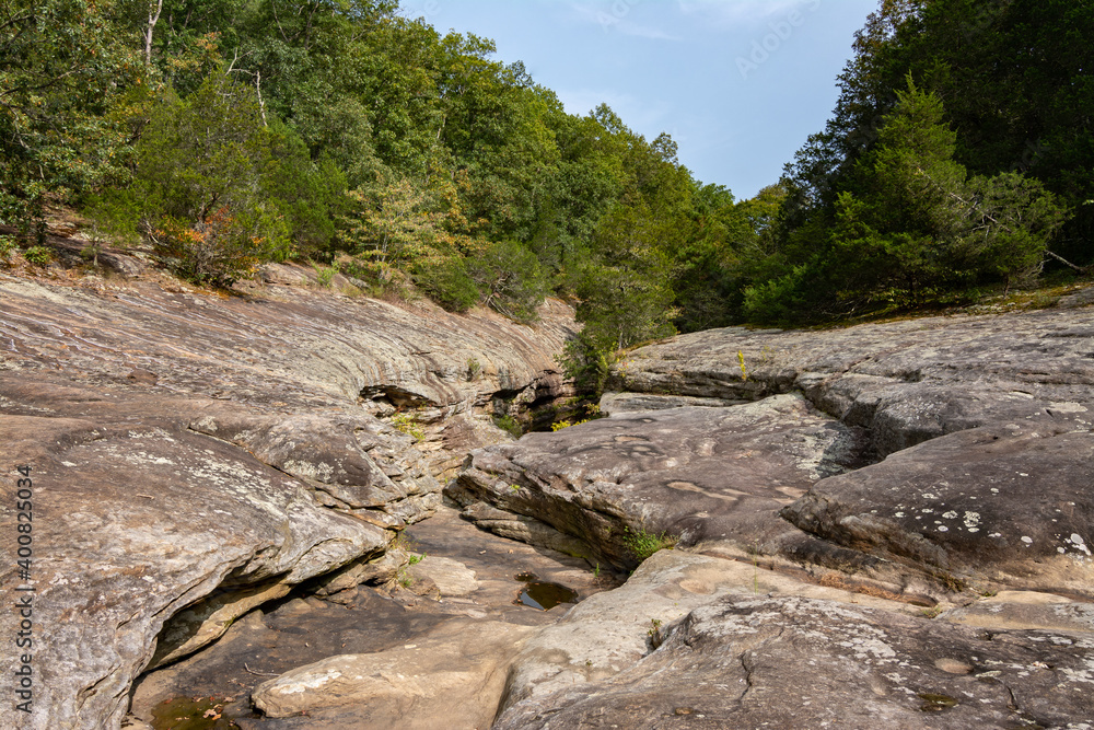 Barren rock formations and small creek run between the trees in the Bell Smith Springs area of the Shawnee National Forest.