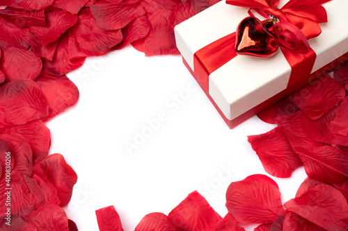 Festive box with bows on rose petals and white blank center for text. Valentine's day concept