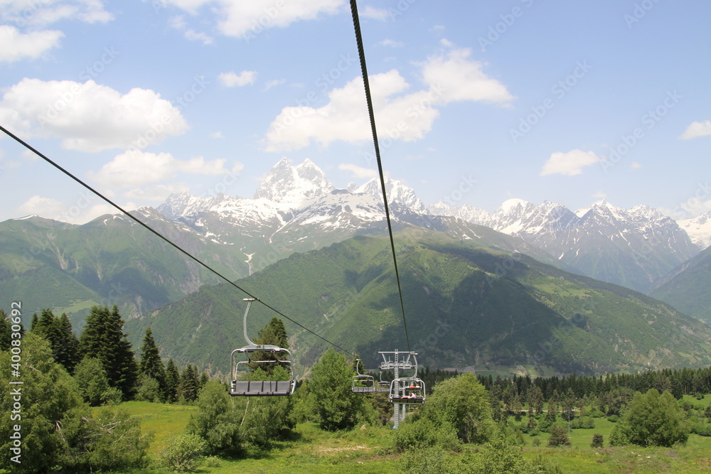 Ski lift on the background of green snowy mountains in Georgia