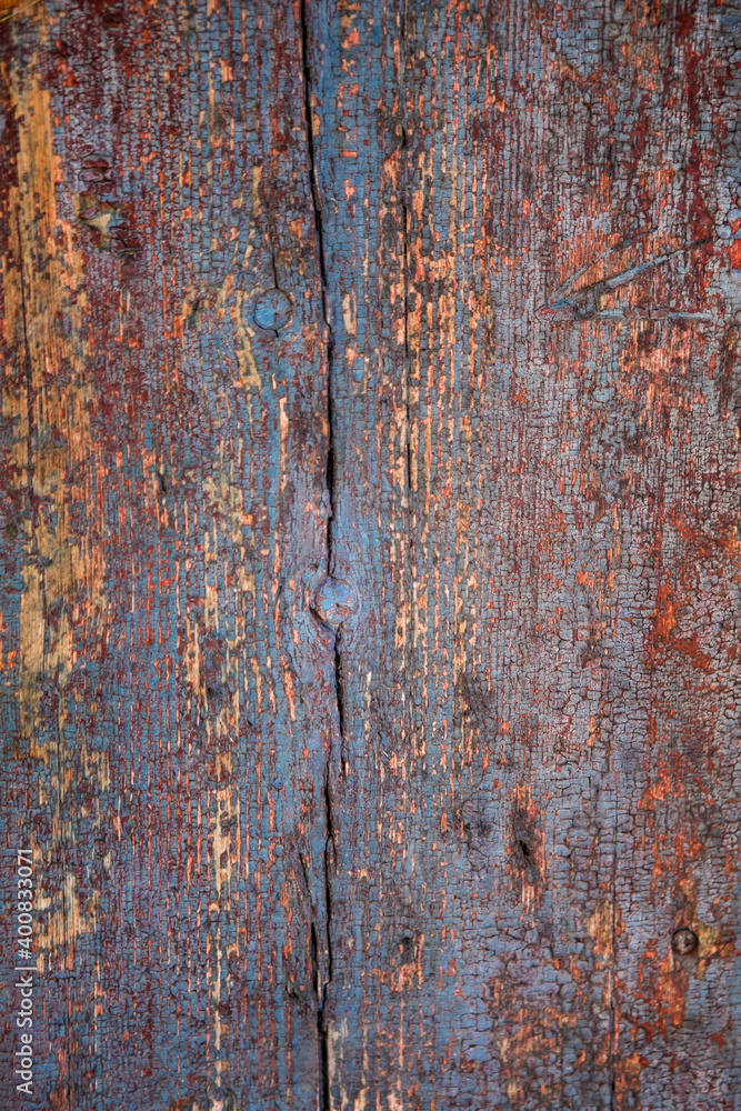 background of an old dark  painted wooden wall of planks wiht knots and cracks