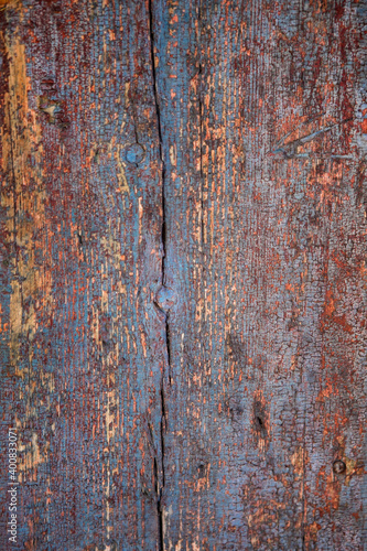 background of an old dark painted wooden wall of planks wiht knots and cracks