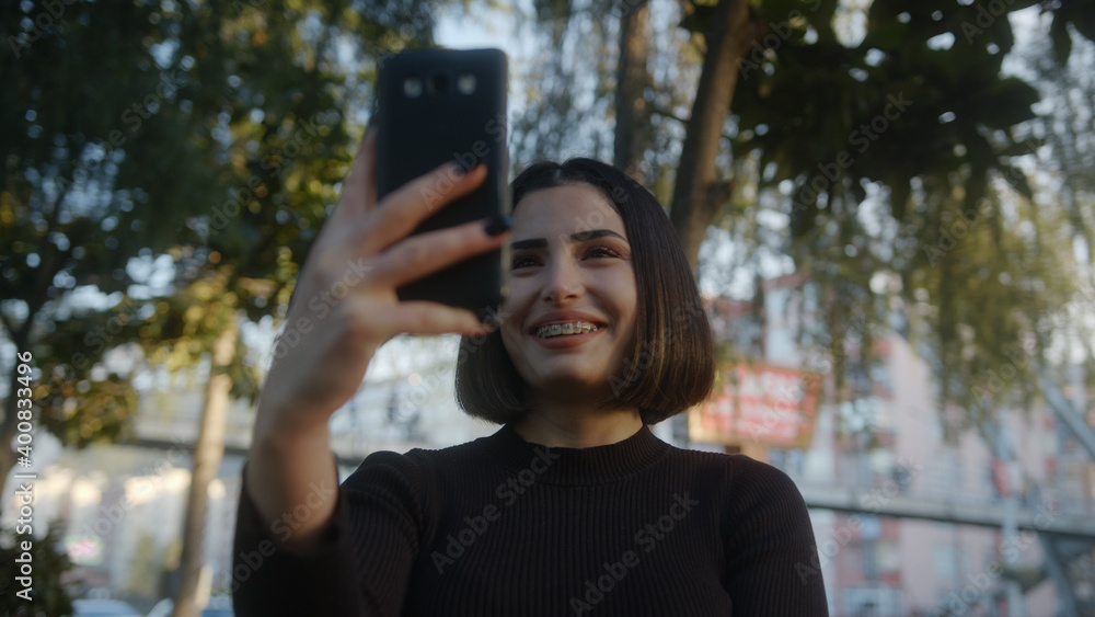 Young woman on the street makes video call on phone. Student making video conference chat, remote relationships, social distancing concept. Young woman on the street makes video call on phone. Student making video conference chat, remote relationships, social distancing concept.