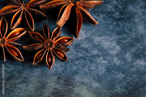 .Overhead shot with copy space. Star anise placed in a corner on dark bluish background
