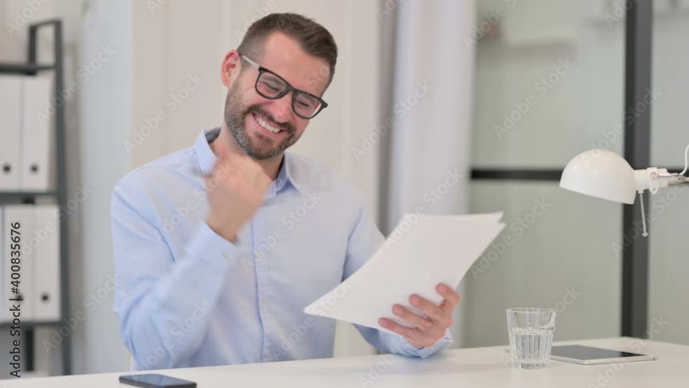 Middle Aged Man Excited by Success on Documents Middle Aged Man Excited by Success on Documents