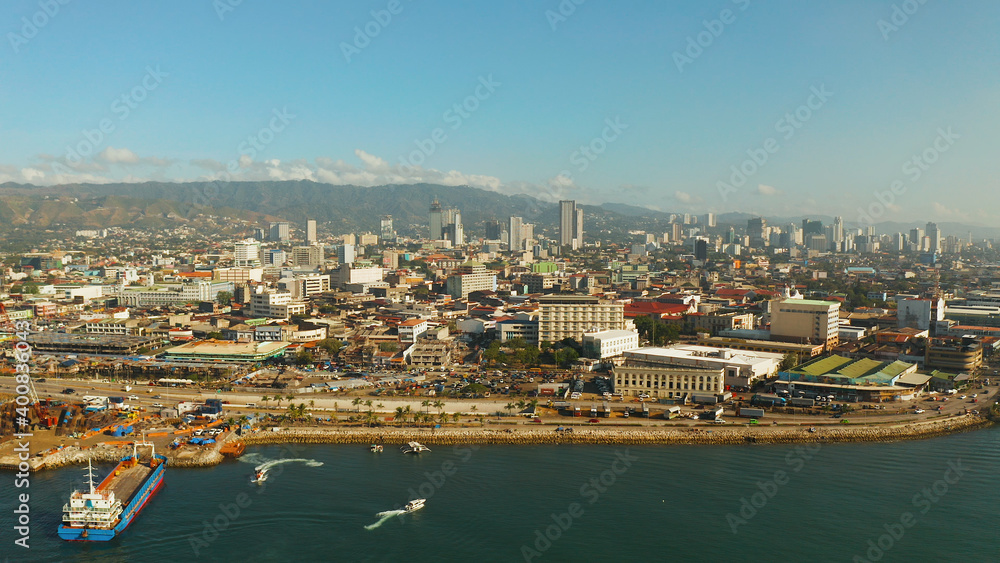 Aerial view of panorama of Cebu city with skyscraper, buildings and seaport with ships and ferries in the early morning. Philippines.