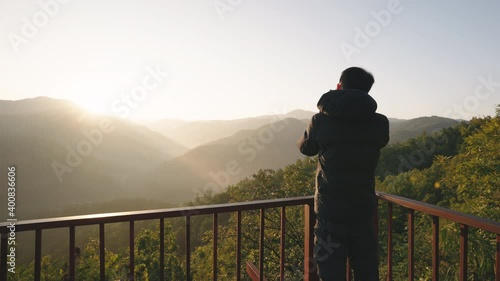 Photographer photographing mountain landscape view in morning at Wat Phrathat Doi Leng viewpoint in Phrae province, Thailand