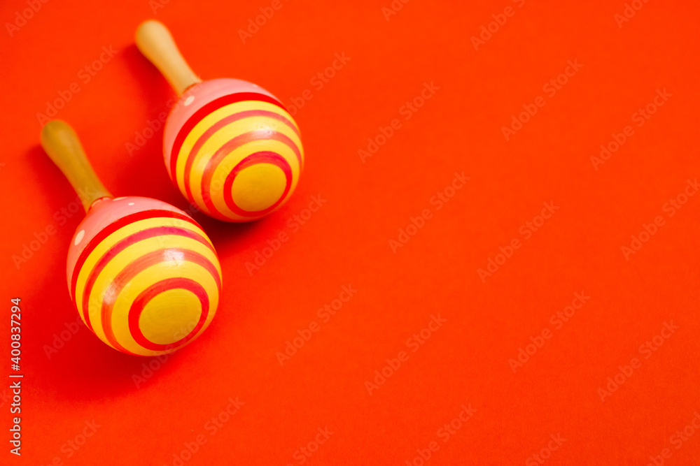 Top view of maracas on a red background. On the right is copy space. Selective focus, shallow depth of field Top view of maracas on a red background. On the right is copy space. Selective focus, shallow depth of field