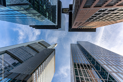 low angle view of four skyscrapers with different facade designs under the blue sky