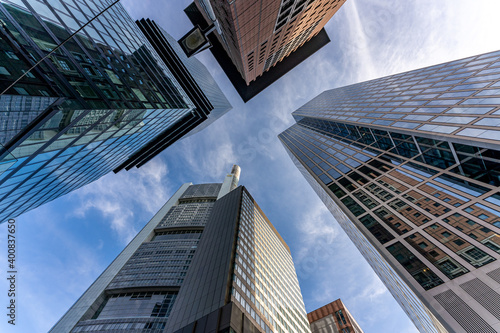 low angle view of four skyscrapers with different facade designs under the blue sky