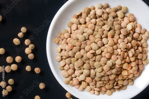lentils on a white plate, the plate is on a glass table