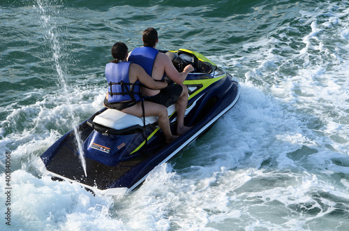 Overhead view of a young couple riding tandem on a jetski.