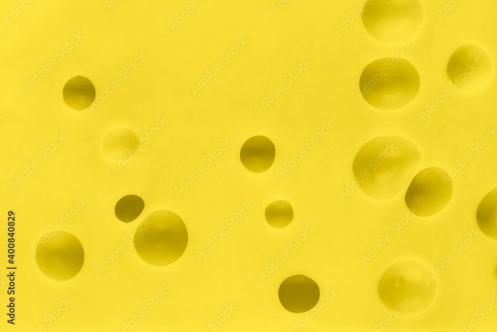 Close up texture of yellow cheese. Cheese with big holes. Food background.