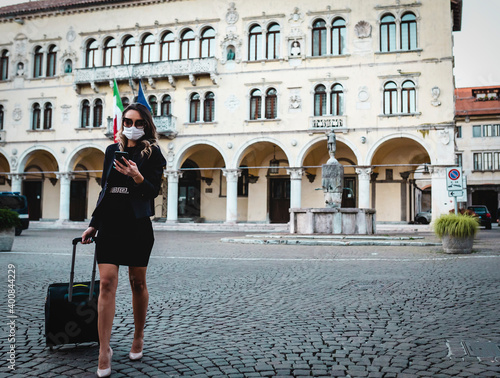 Business woman walks in the city with mask.