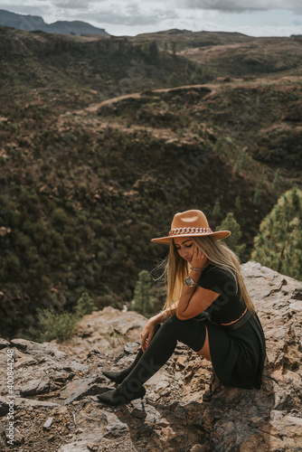 young woman with hat in the field looking at the camera