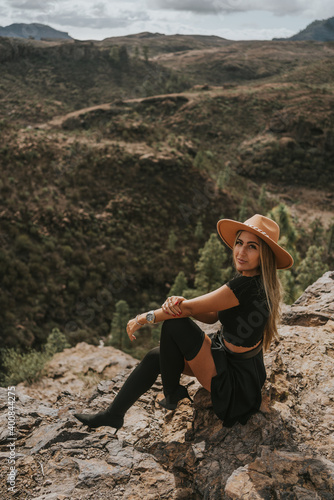 young woman with hat in the field looking at the camera
