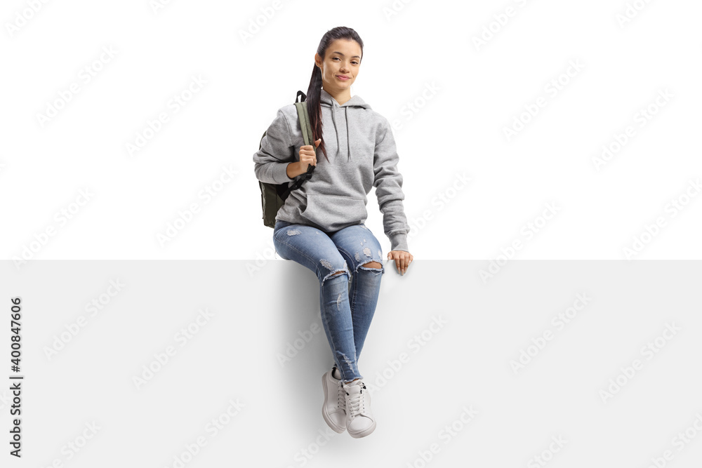 Mixed race female student sitting on a blank board and smiling at camera Mixed race female student sitting on a blank board and smiling at camera