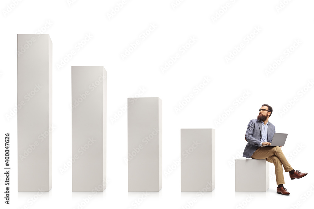 Professional man with a laptop sitting on a column and looking at rising column bars Professional man with a laptop sitting on a column and looking at rising column bars