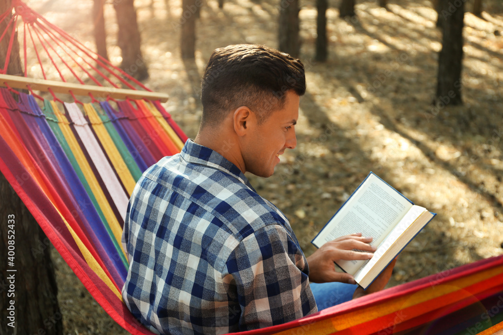 Man with book relaxing in hammock outdoors on summer day Man with book relaxing in hammock outdoors on summer day