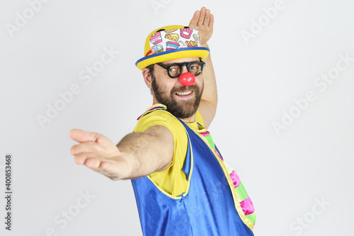 The clown is a man in a bright blue and yellow suit, glasses and a hat, playing emotionally.