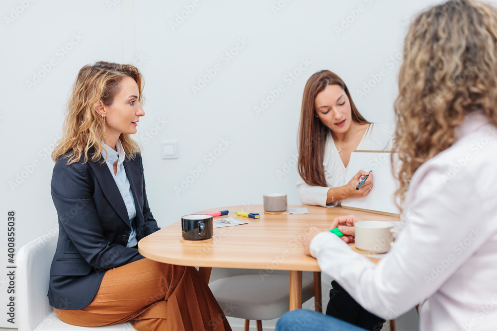 Woman explaining chart on note pad at office Woman explaining chart on note pad at office